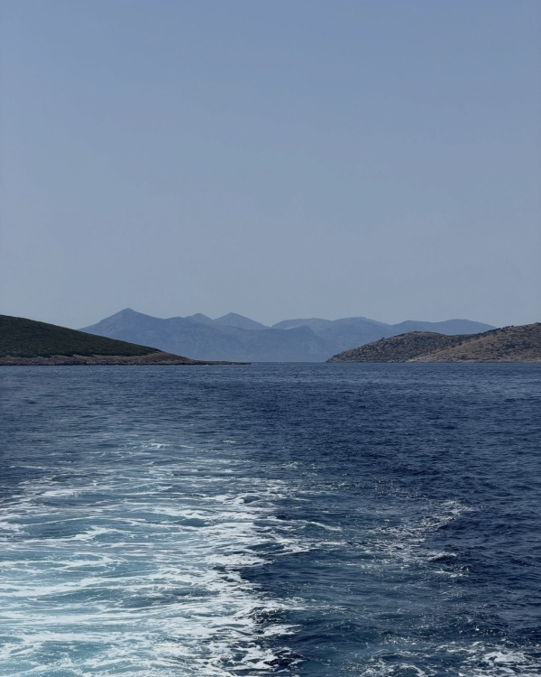 Пенный след за яхтой на фоне гор и синего моря у берегов Сардинии